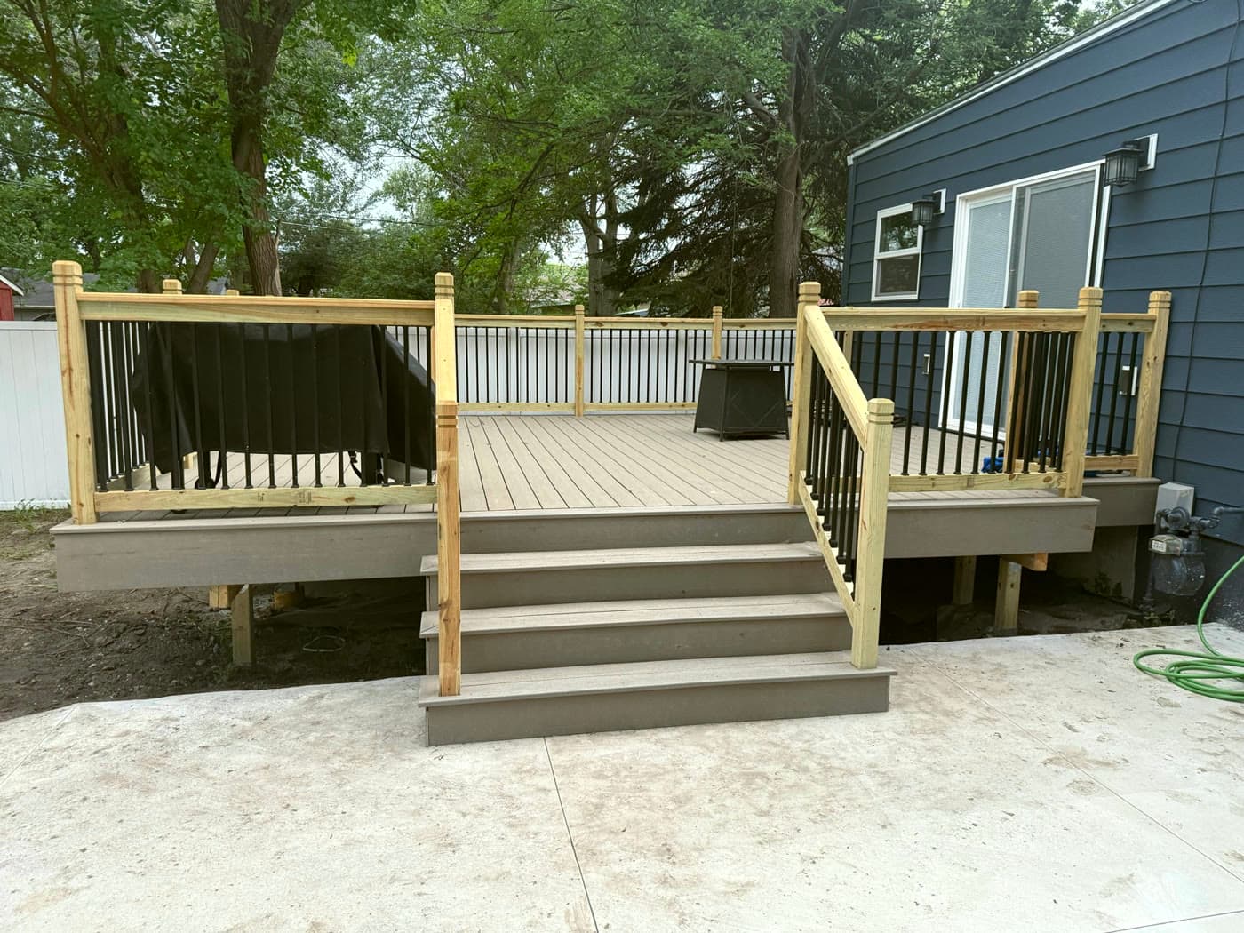 Composite deck with railings stepping down to a patio